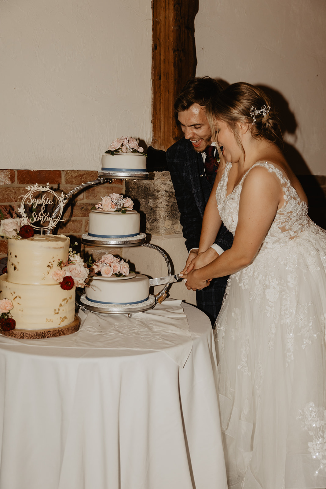 Bride and groom cutting their wedding cake at a wedding at Long Furlong Barn, Sussex. By OliveJoy Photography