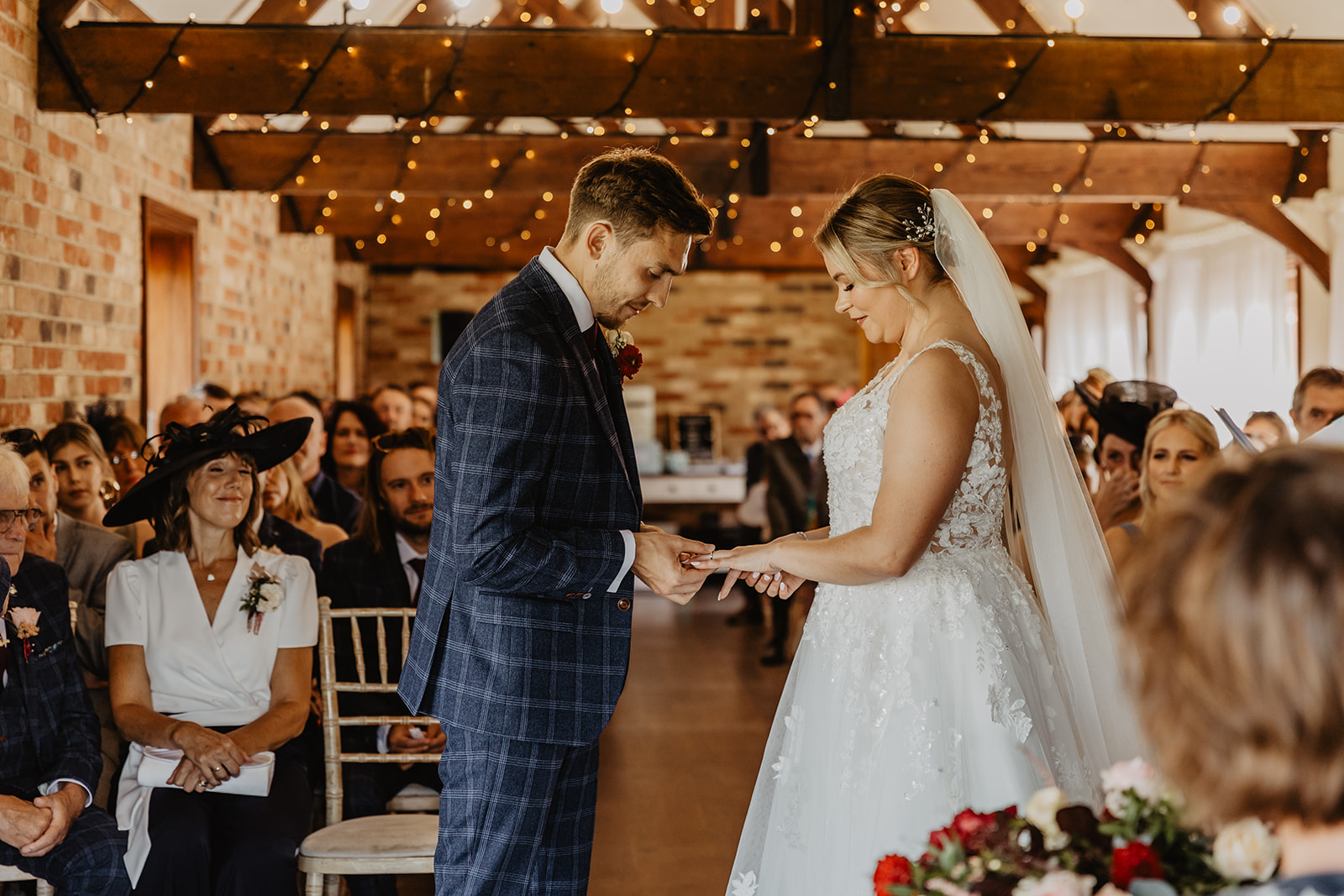 Bride and groom exchange rings at a wedding at Long Furlong Barn, Sussex. By OliveJoy Photography.