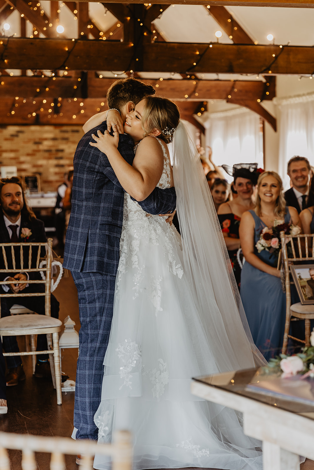 Bride and groom hug at a wedding at Long Furlong Barn, Sussex. By OliveJoy Photography.