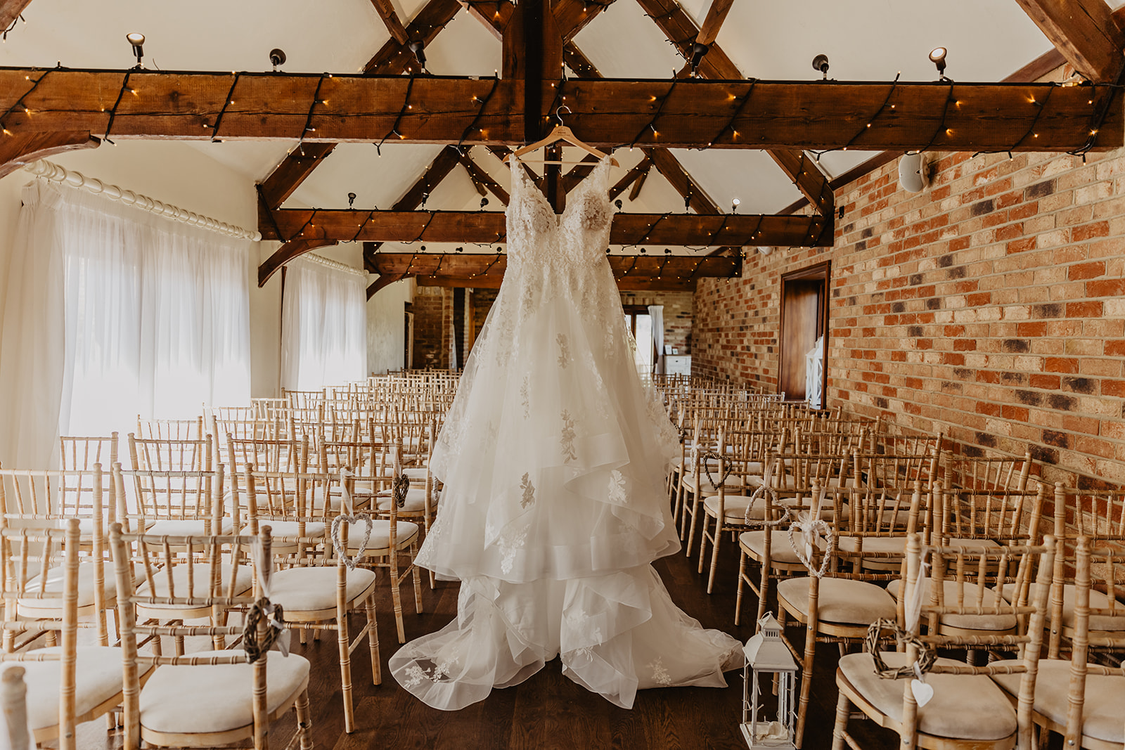 Wedding dress hanging up at a wedding at Long Furlong Barn, Sussex. By OliveJoy Photography.