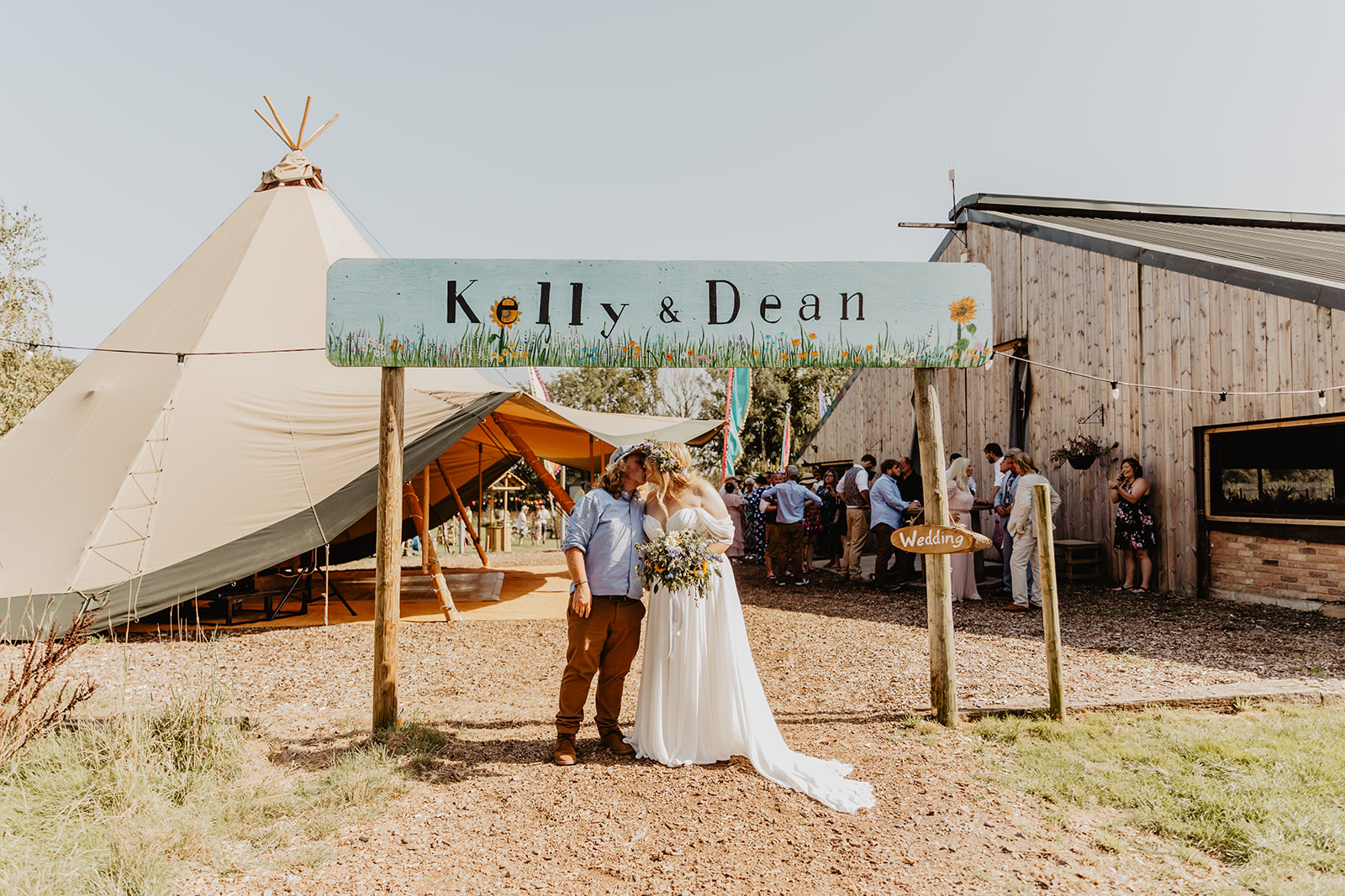 Bride and Groom under wedding banner at a wedding at Mac's Farm in Sussex. By OliveJoy Photography.