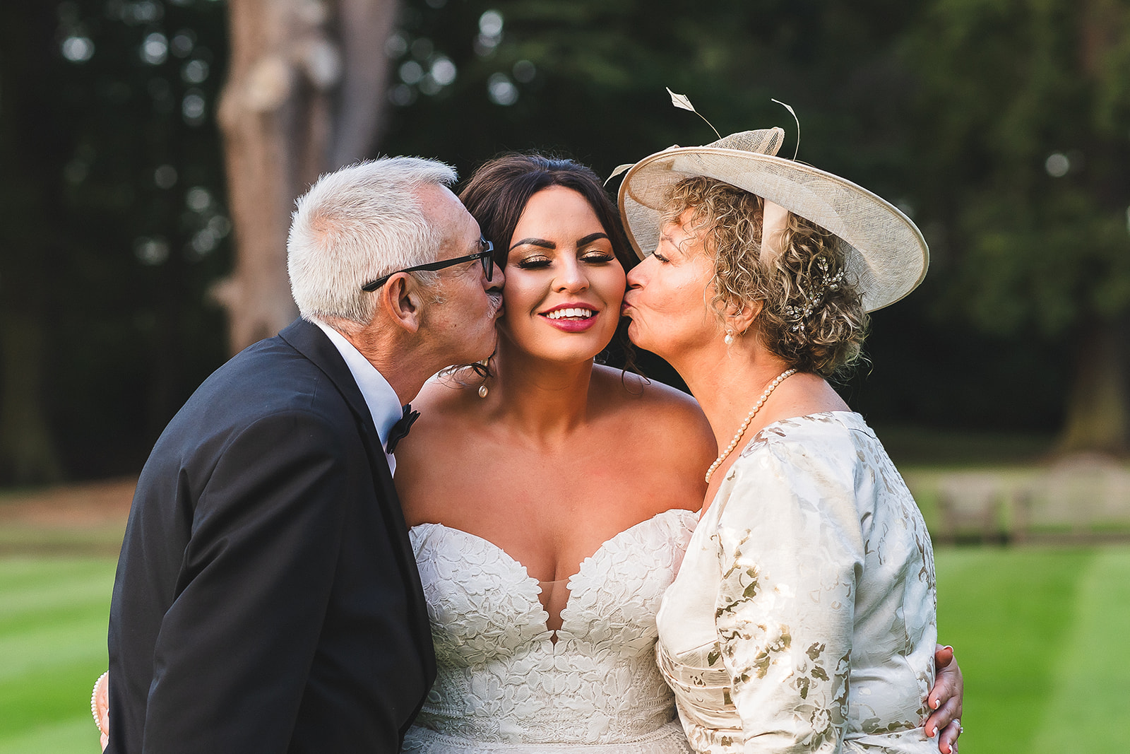 bride with mum and dad kissing