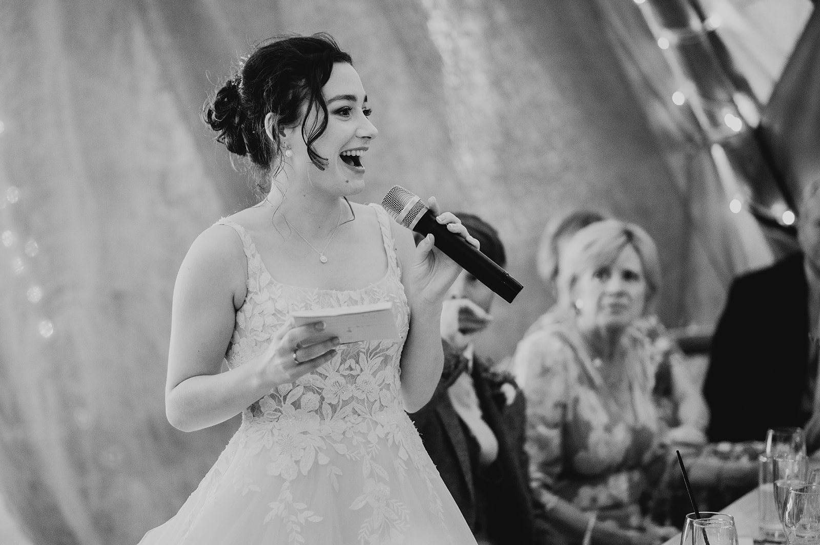 A bride gives a speech in tipi at Holywell estate
