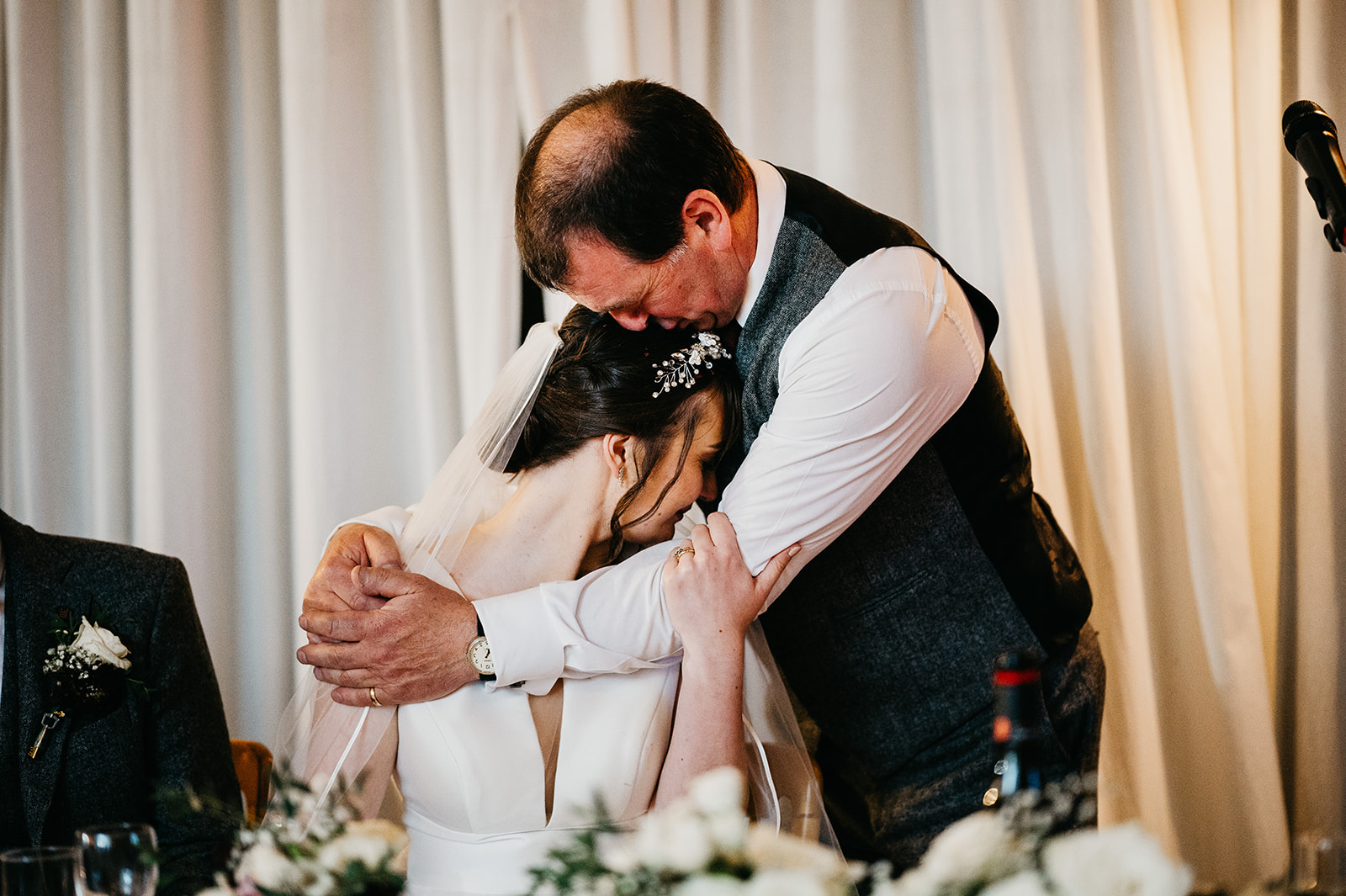 father of the bride hugs the bride during speeches