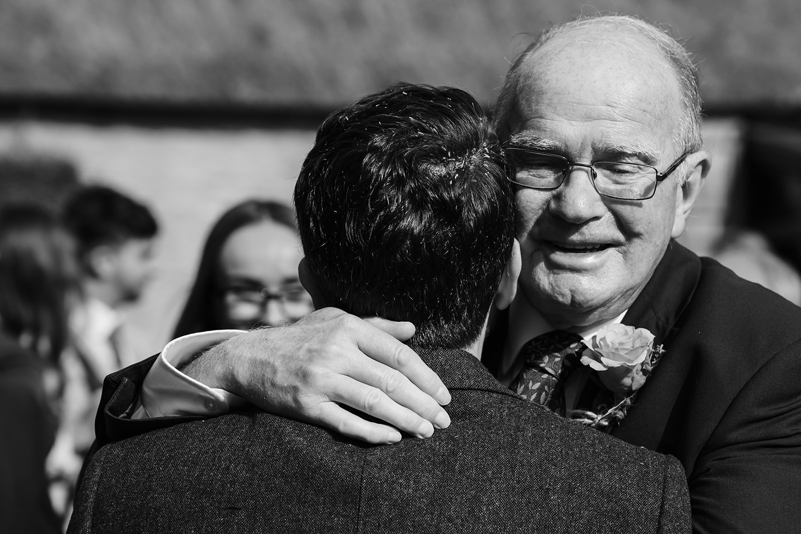 Groom hugging grandparent after wedding ceremony 