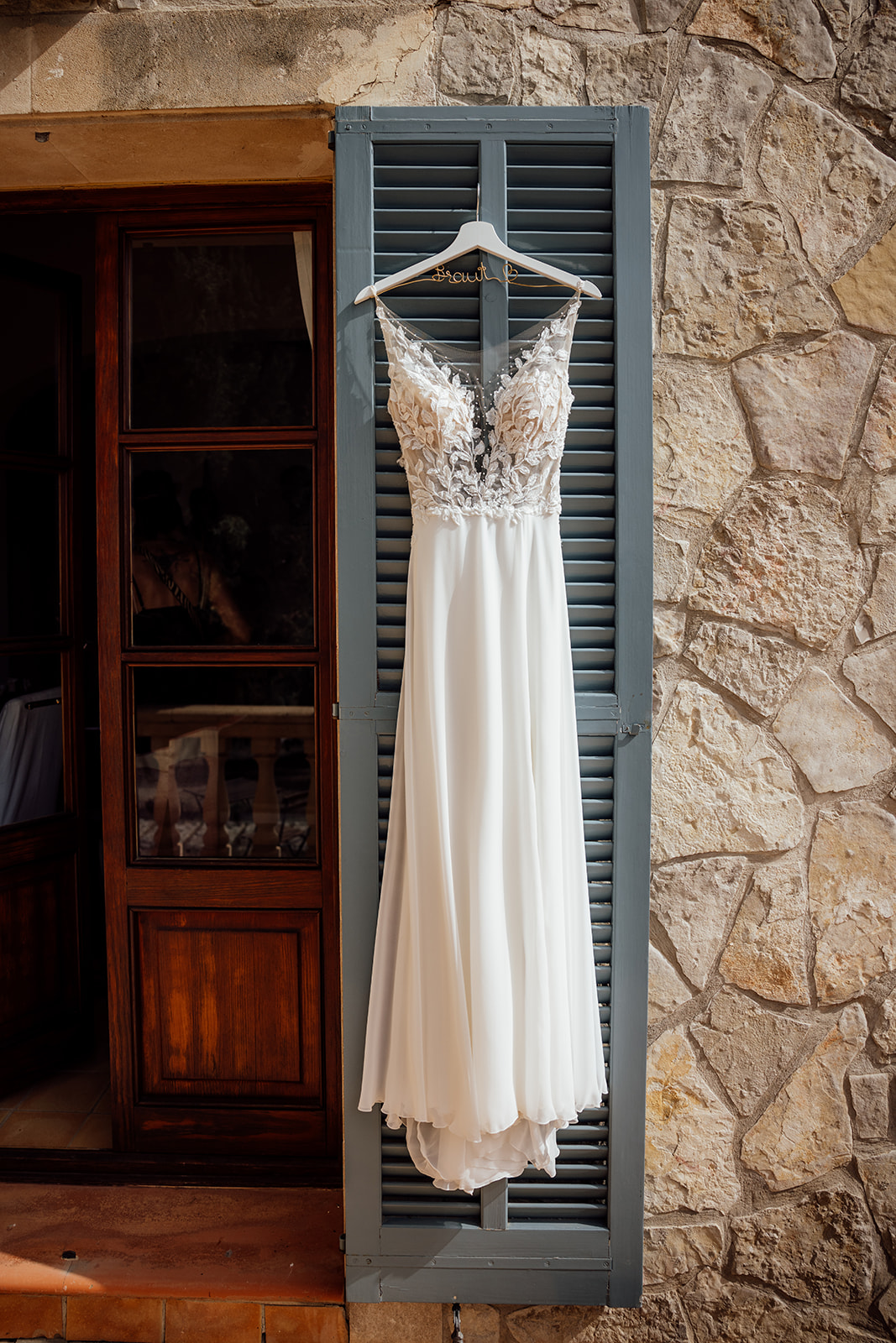 Brautkleid hängt an Fensterladen Fincahochzeit Mallorca Son Canals 