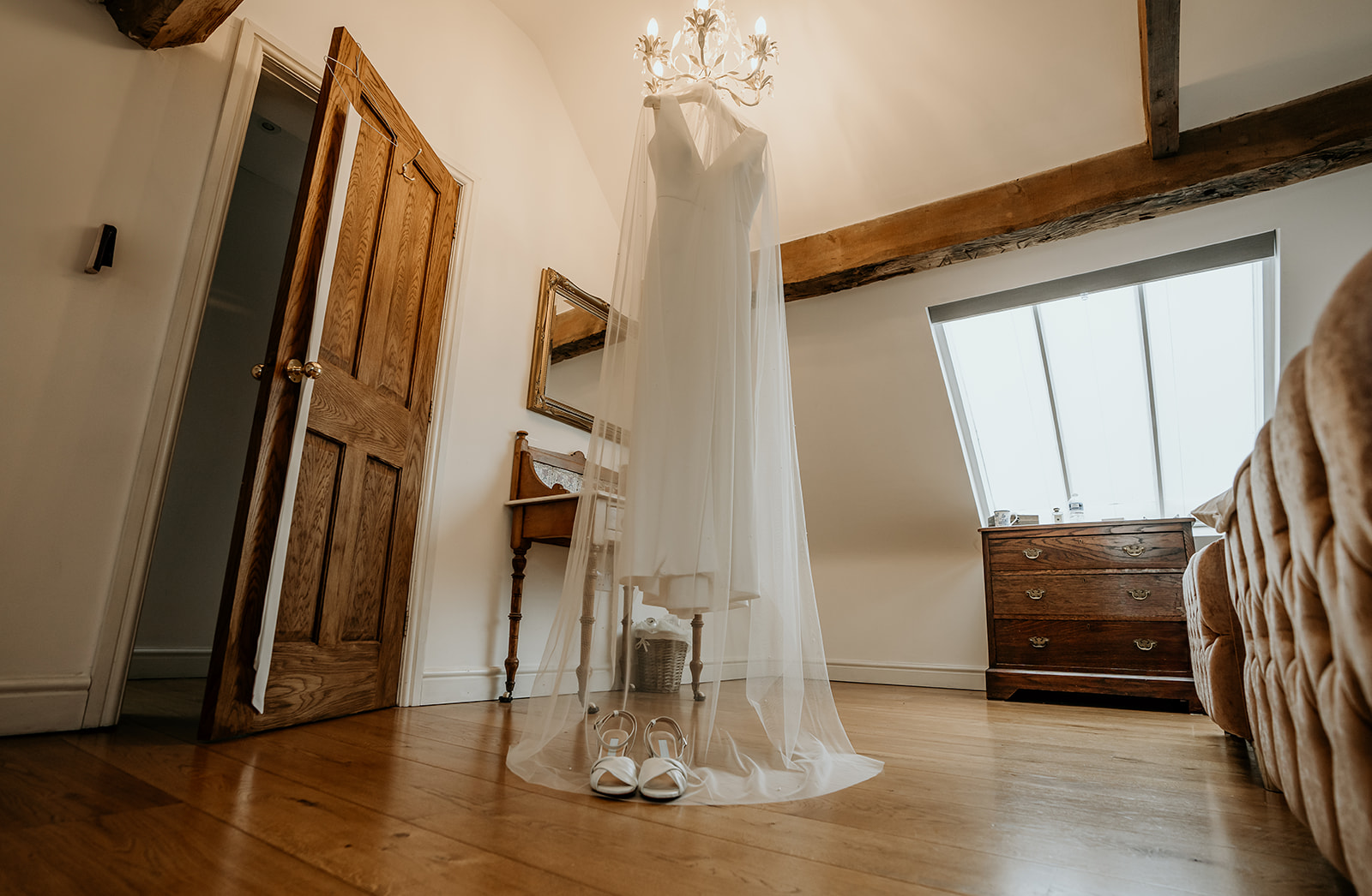 brides wedding dress hung in barn