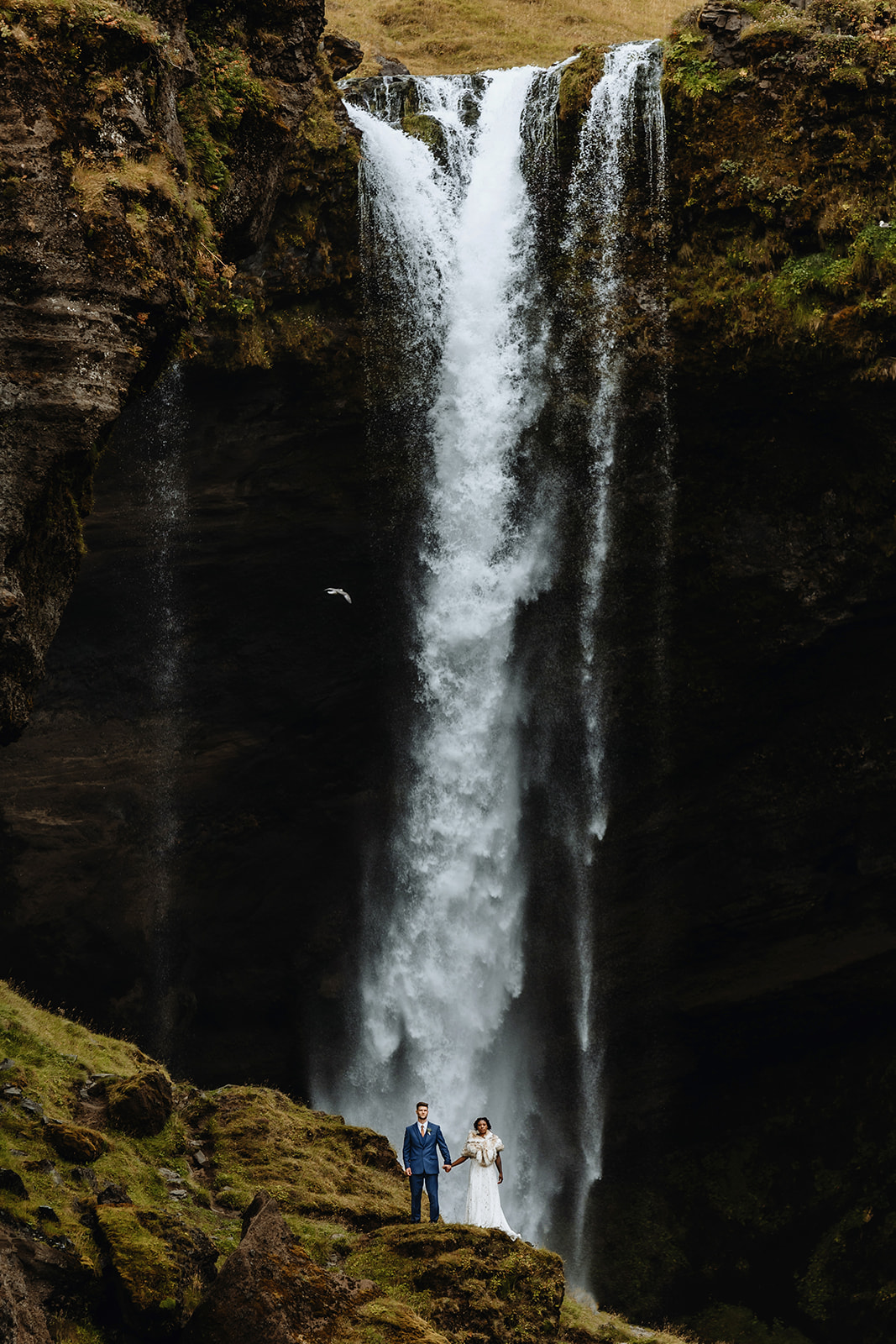 Dramatic waterfall shot of a married couple in Iceland