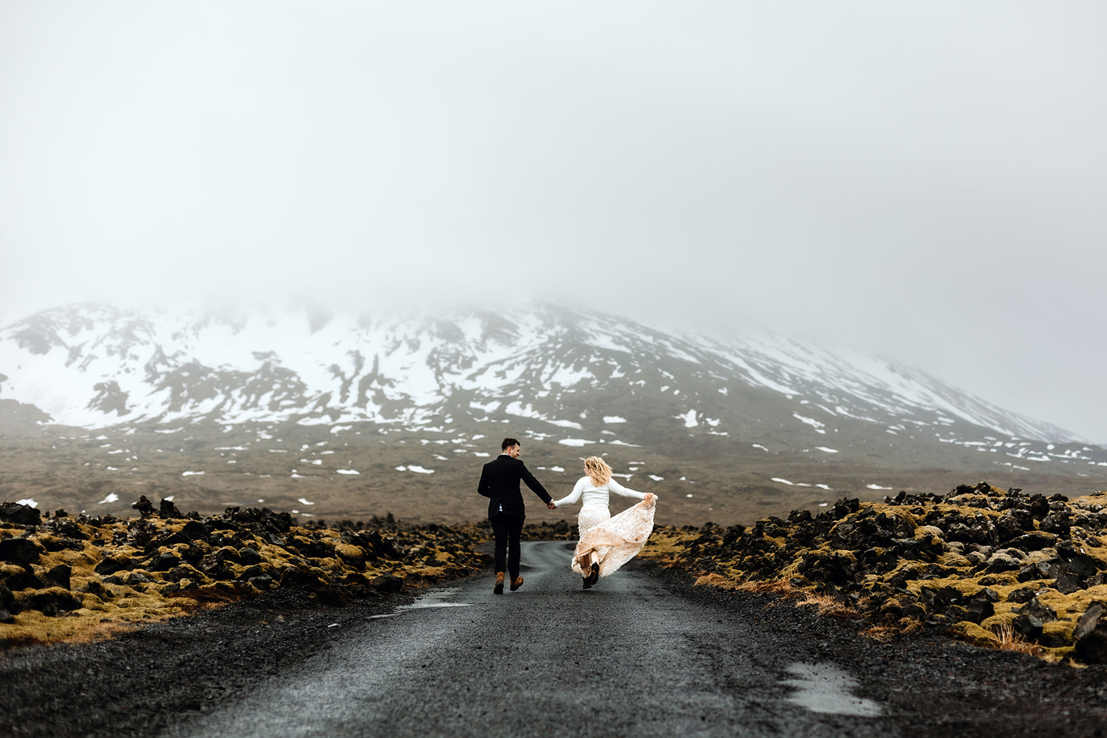 Newlywed couple is running on a lava field on their elopement day in Iceland