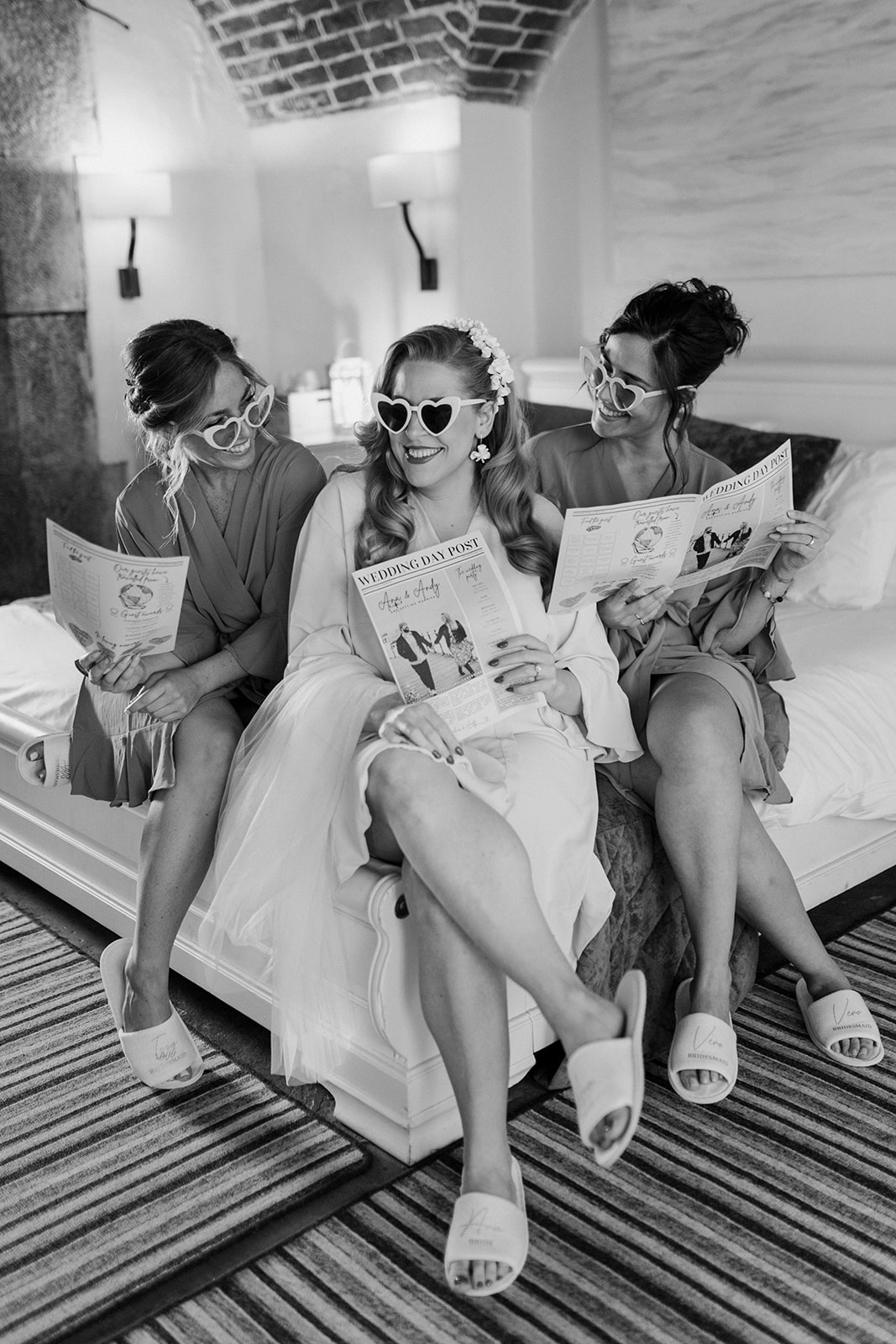 Bride and bridesmaids pose with sunglasses and newspaper