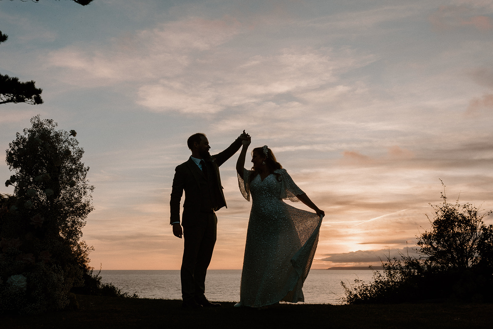 Bride and groom dance at sunset at Polhawn Fort