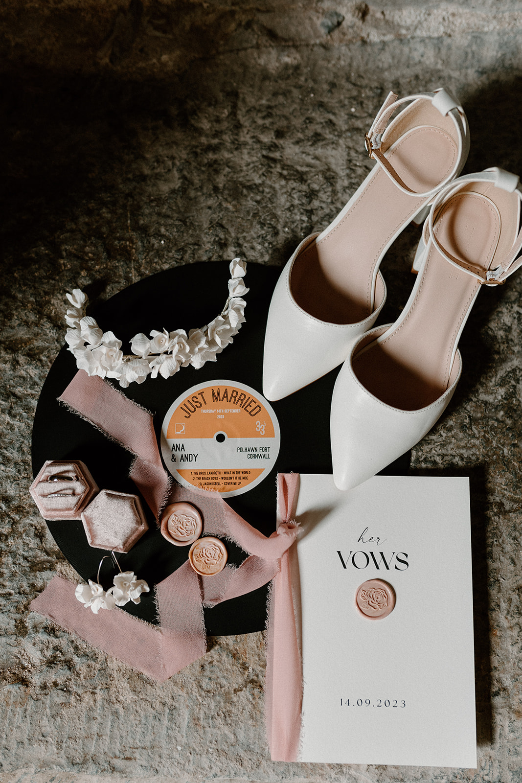 Flat lay of bridal details including shoes, wedding vows and vinyl record.