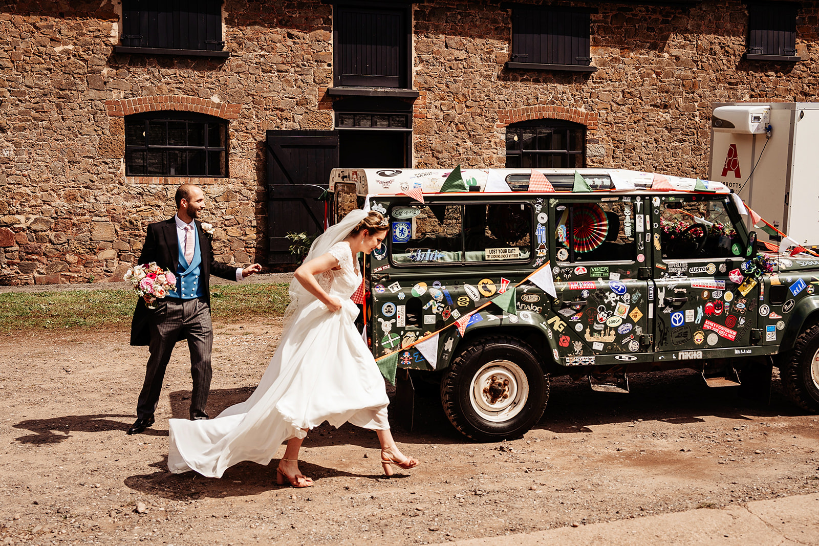 bride and groom with land rover wedding car