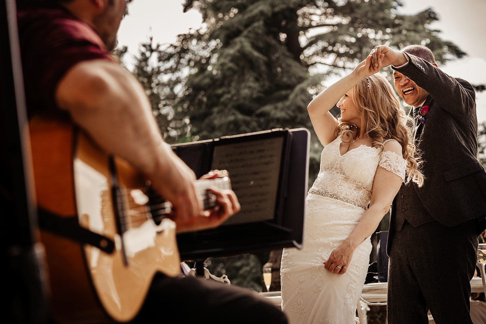 bride and groom dancing to guitar outside