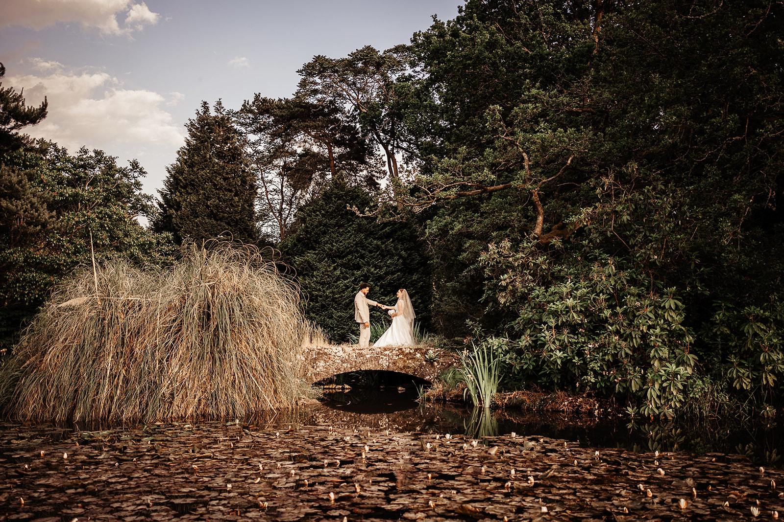 bride and groom on bridge at Tylney Hall