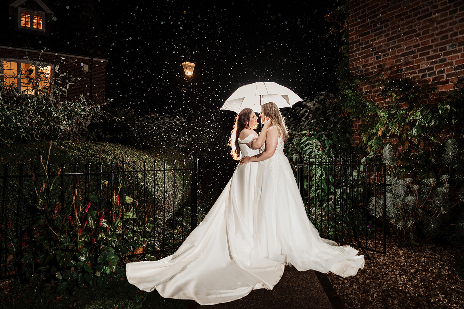 two brides rain night portraits umbrellas clock barn