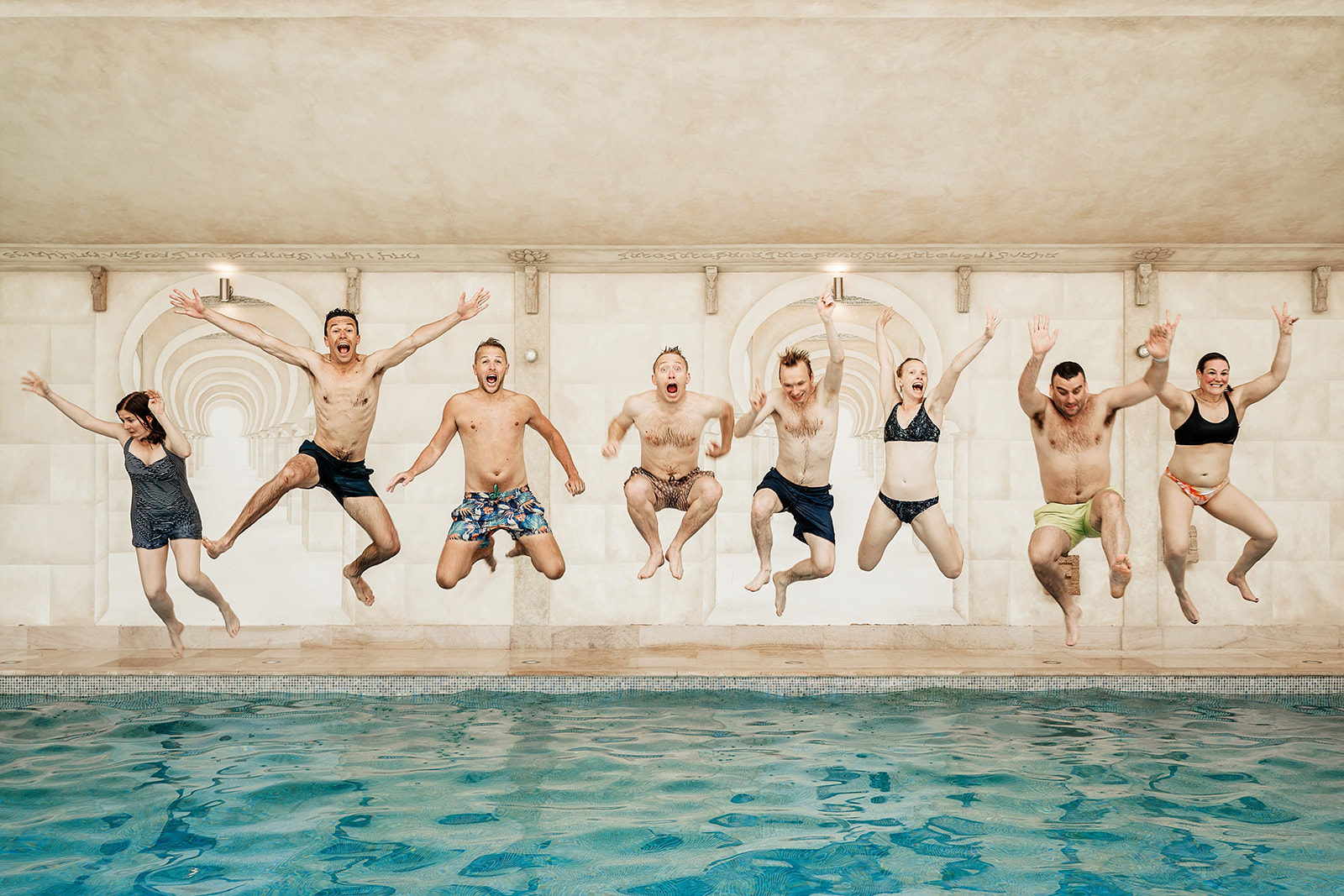 wedding party jumping into swimming pool