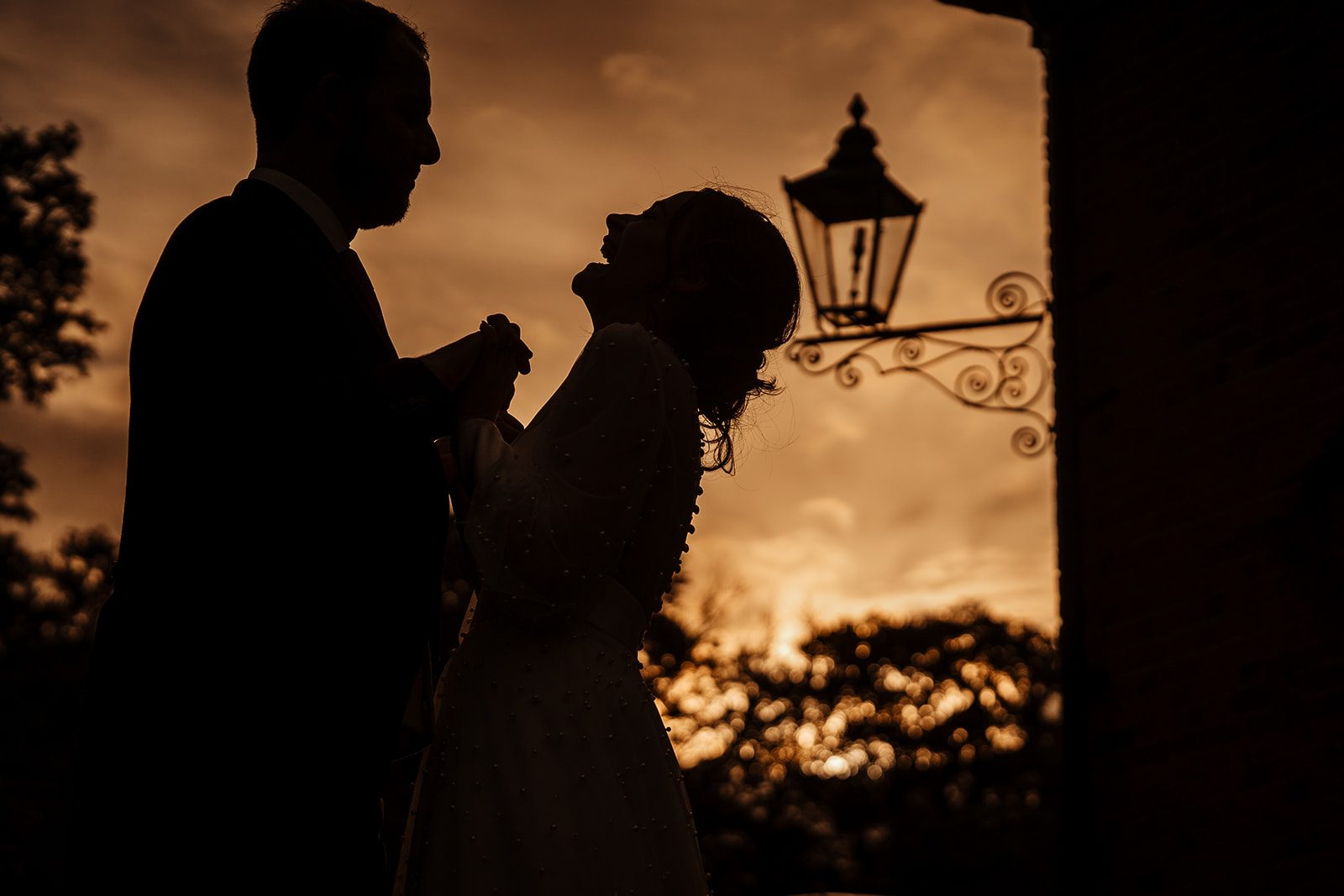 bride and groom sunset silhouette laughing