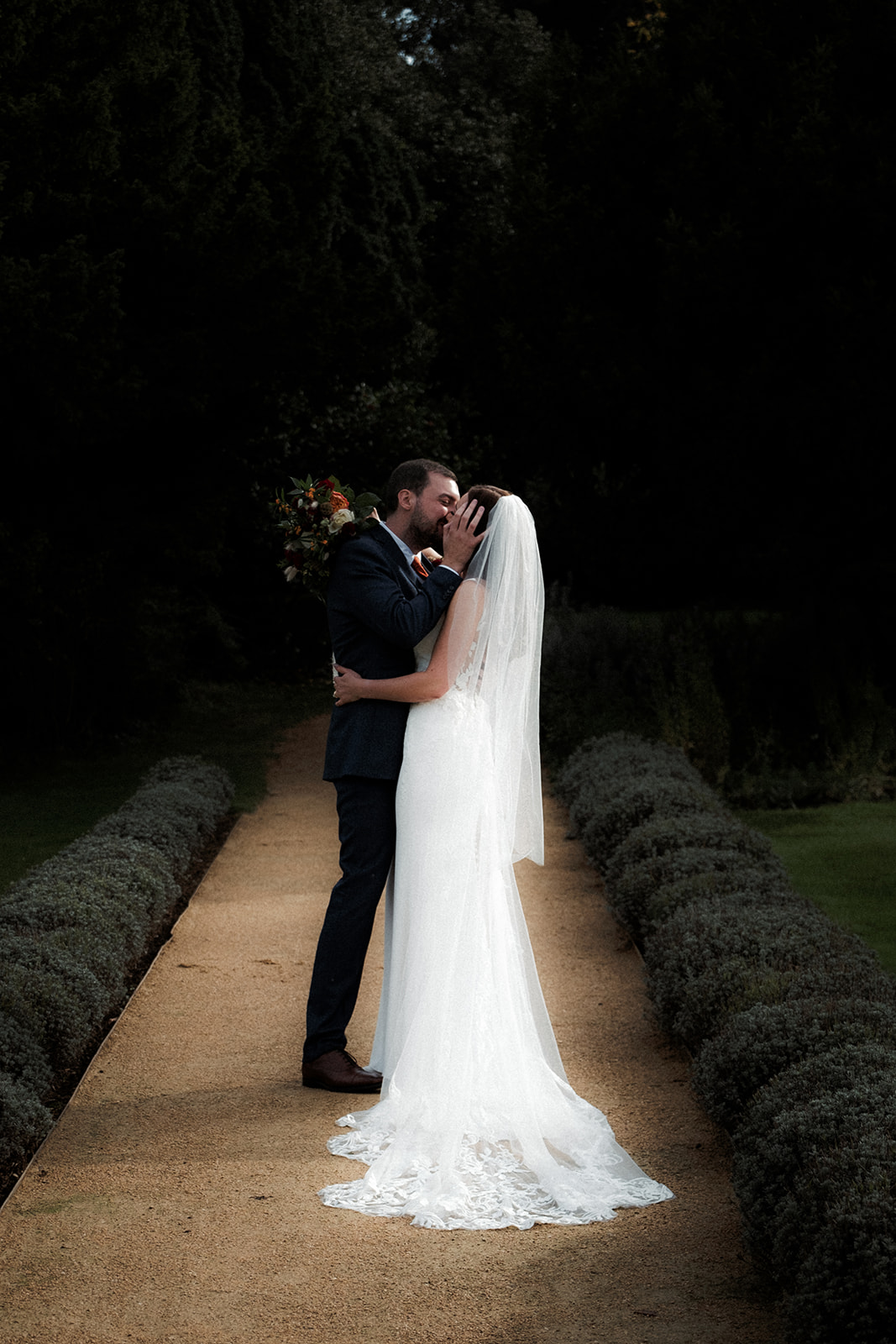 Bride and Groom share a passionate kiss amongst the grounds of Clevedon Hall