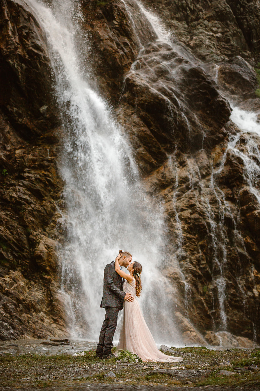 Waterfall photo of a couple eloping on the mountains in Italy