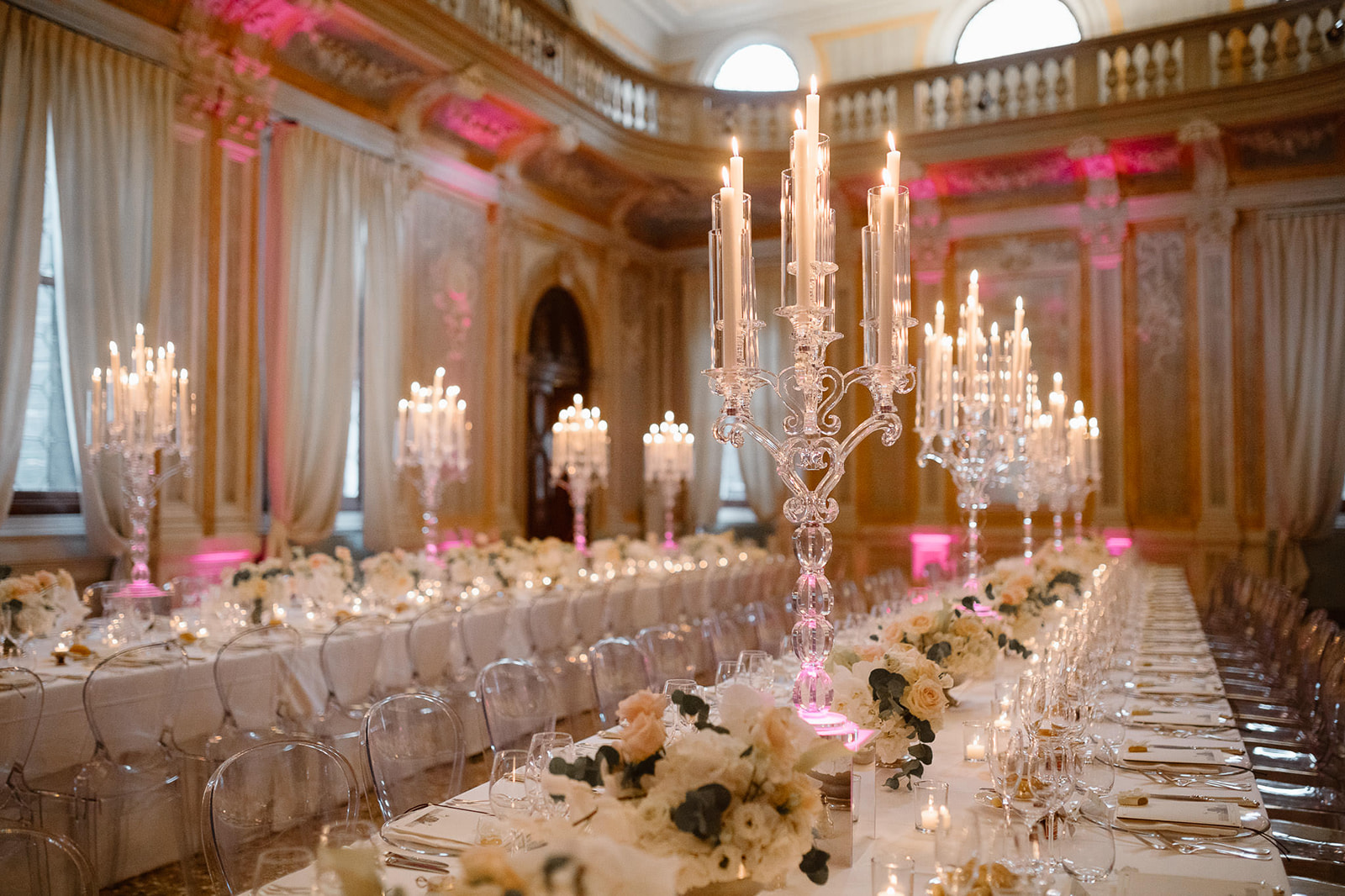 Chandeliers and color lights at the wedding dinner, the settings is made by Brilliant Weddings Venice