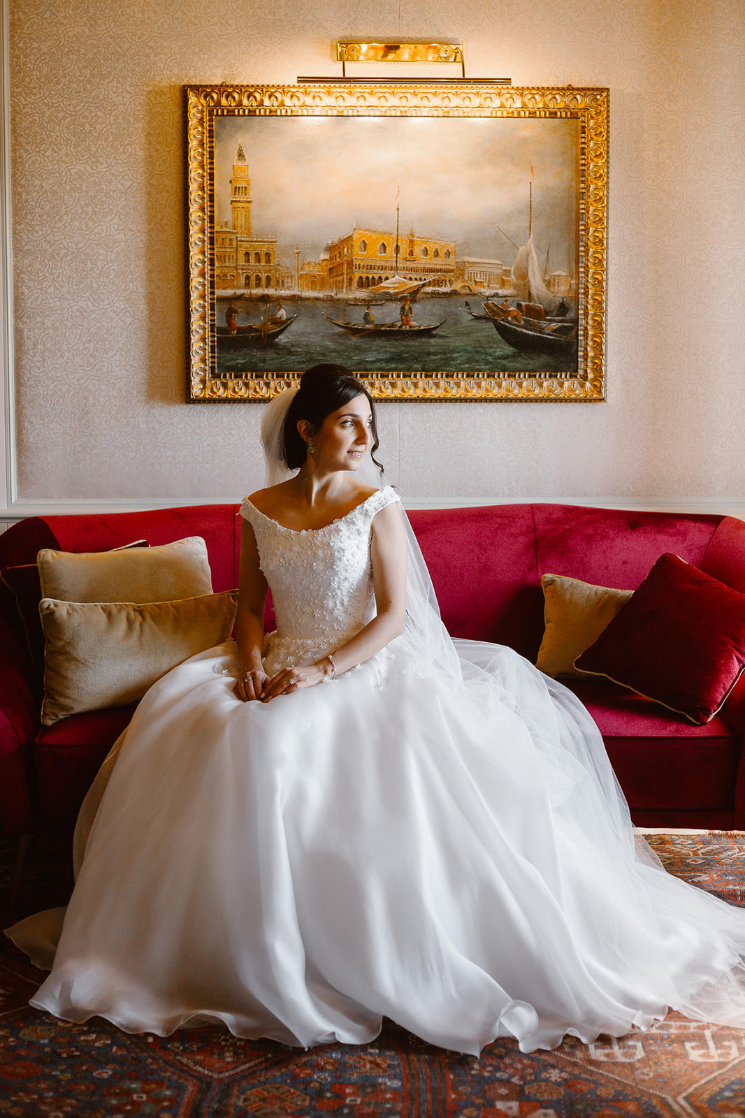 Bride portrait sitting on a red sofa at Hotel Monaco Grand Canal