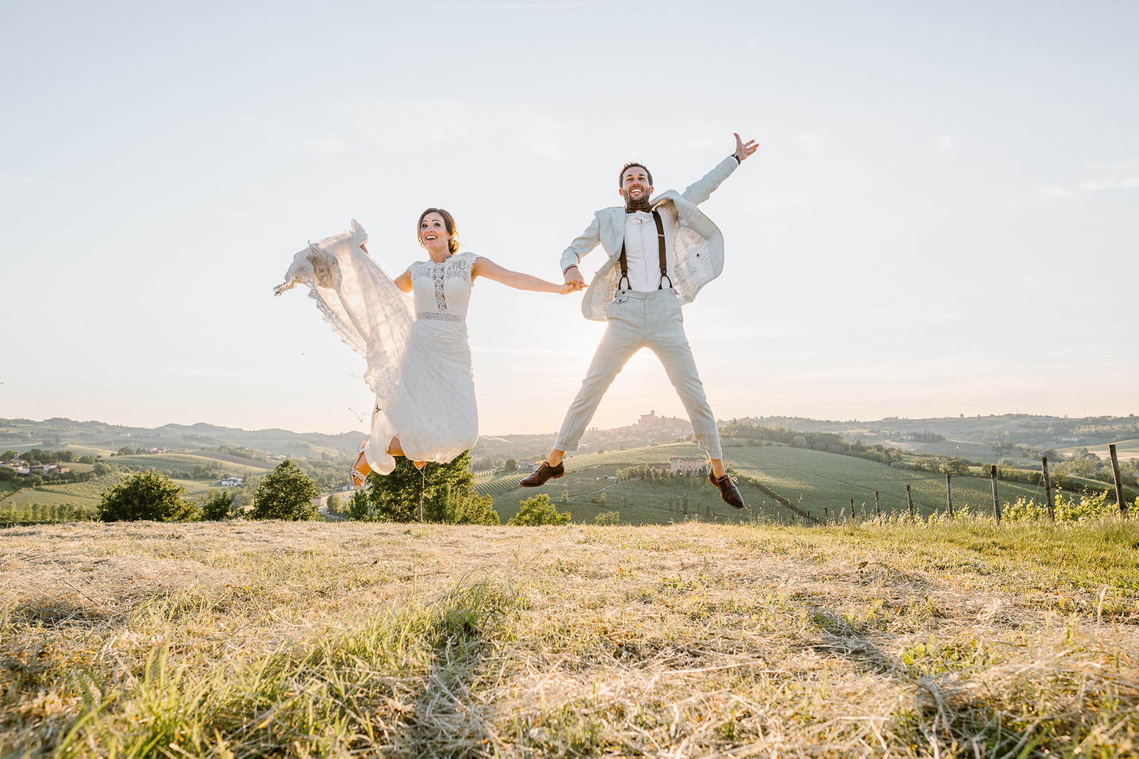bride and groom jumping and having fun during their wedding photo shoot in Italy