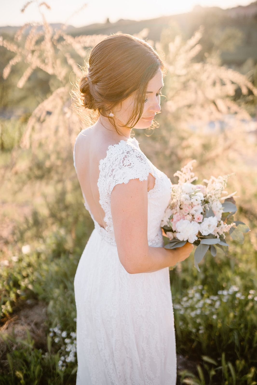 portrait of a bride with an elegant white dress and pastel tones wedding bouquet taken by her wedding photographers in I