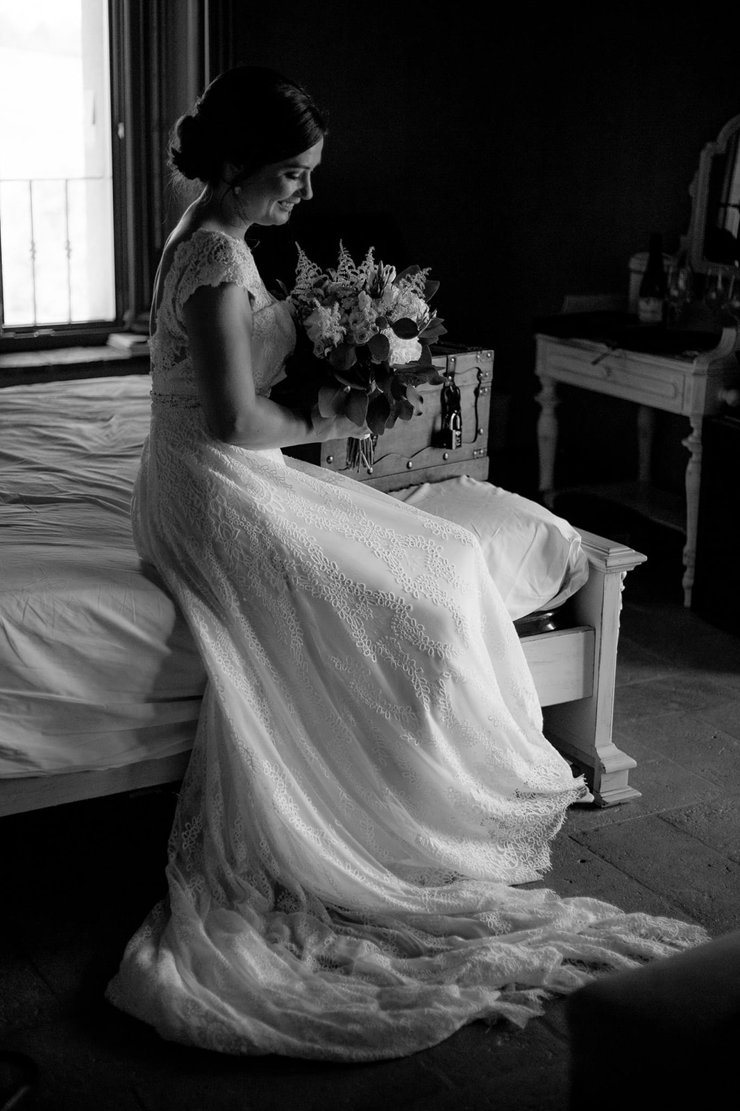 Portrait of the bride sitting on the bed, in black and white