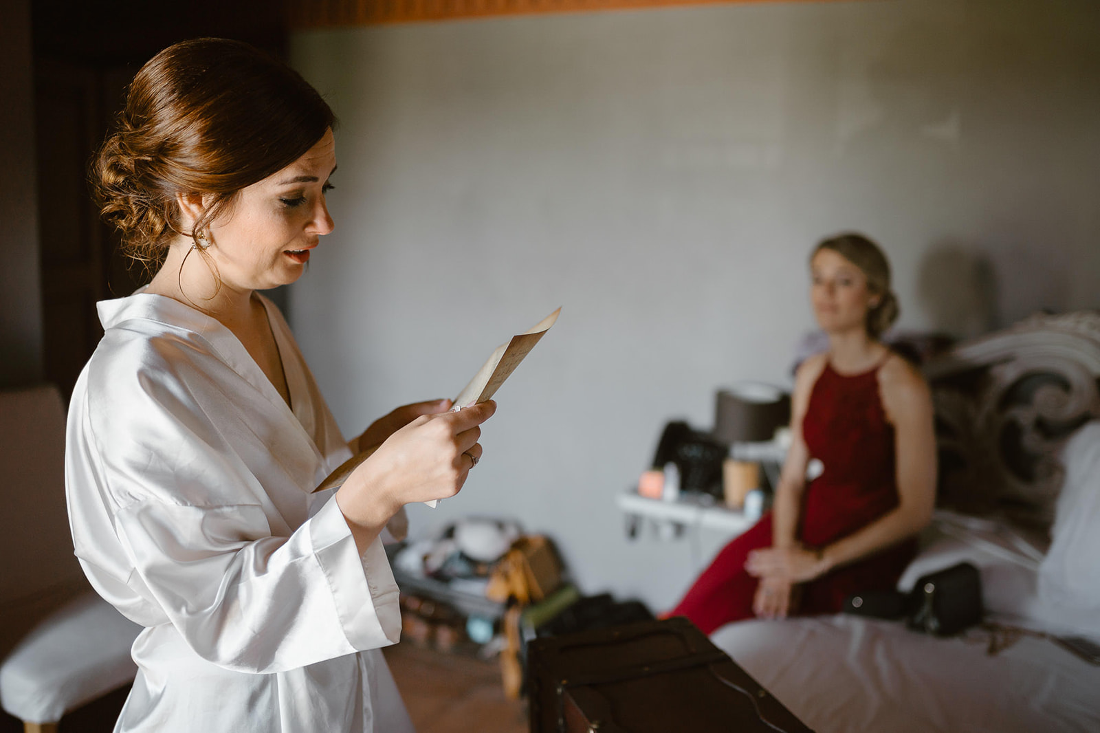 Bride reads a letter received from the groom in her room at Cascina Faletta