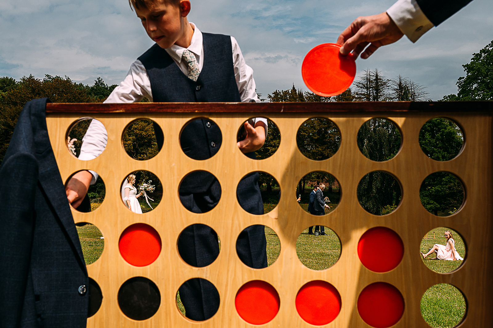 Guests playing connect 4  with other guests in the background shown through the circles.