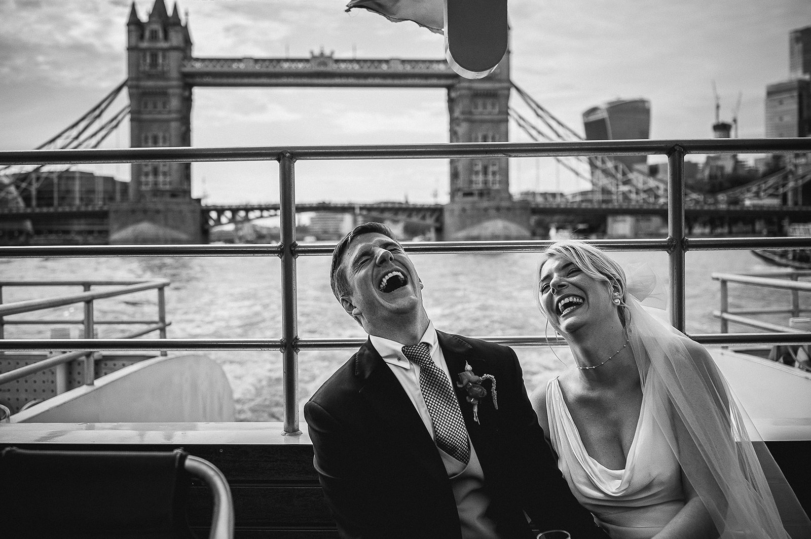 Top couple laughing at their wedding on the Thames