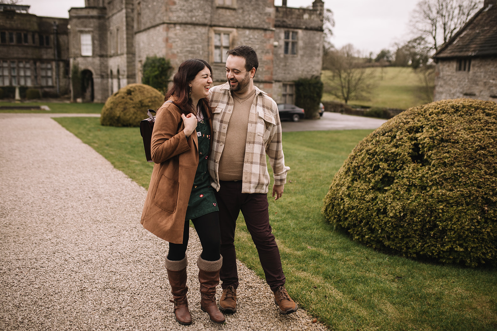 a couple laughing walking in front of Tissington Hall 
