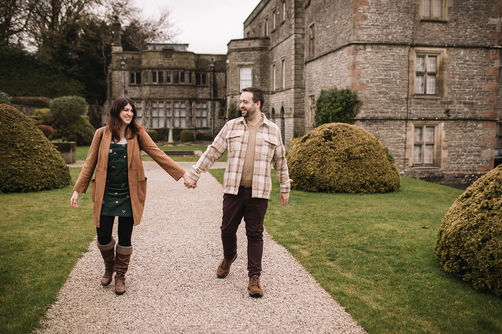 A couple walking in front of Tissington Hall 