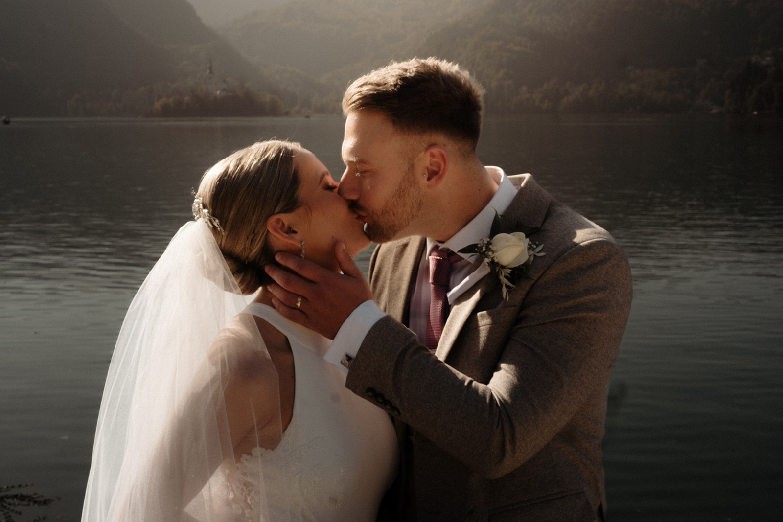 Bride and Groom share a moment of romance with Lake Bled in the background