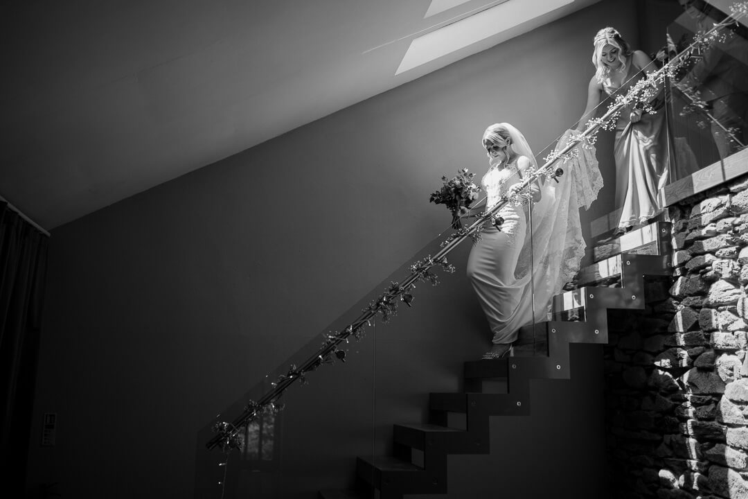 Bride descends staircase at Trevenna Barns.