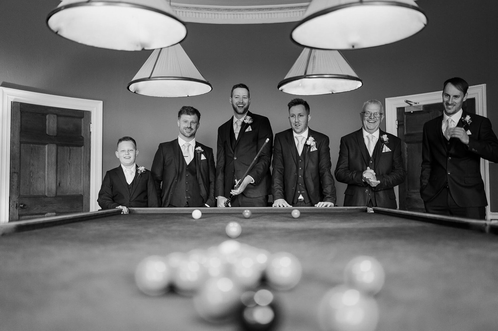 Groom and groomsmen enjoy a game of snooker at Rockbeare Manor before the wedding ceremony. 