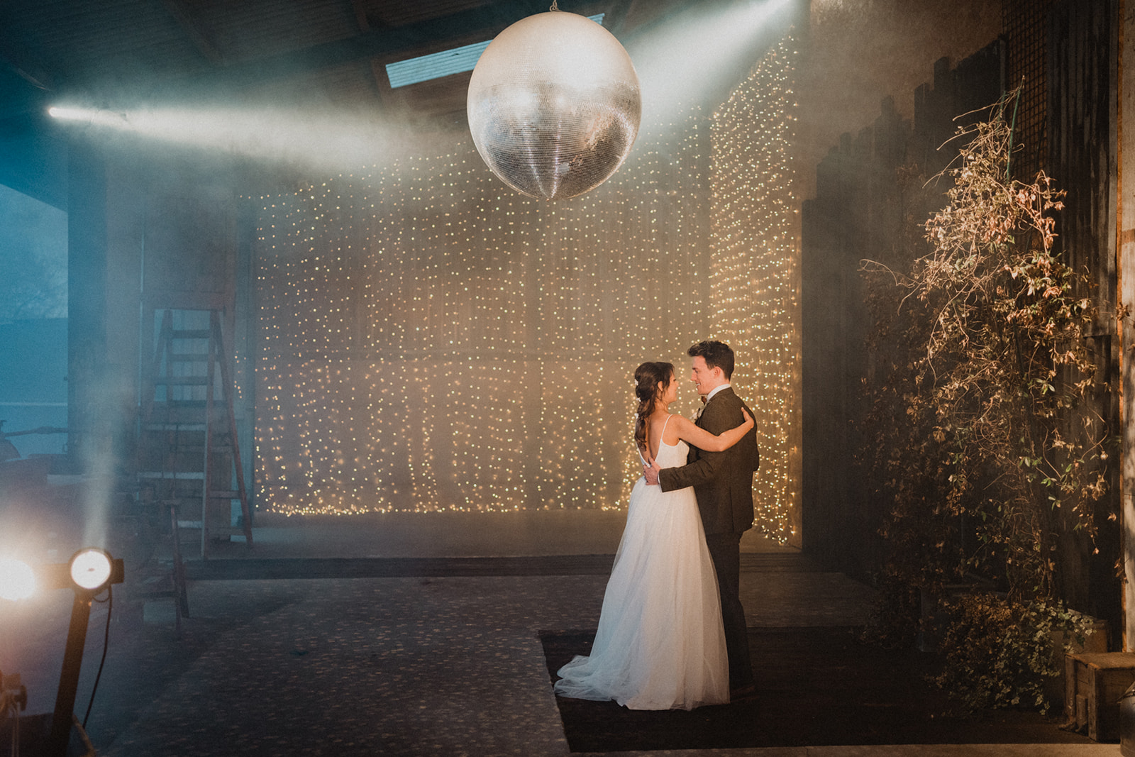 Bride and groom dancing together in beneath a disco ball in the Shooting Gallery at Owen House Wedding Barn