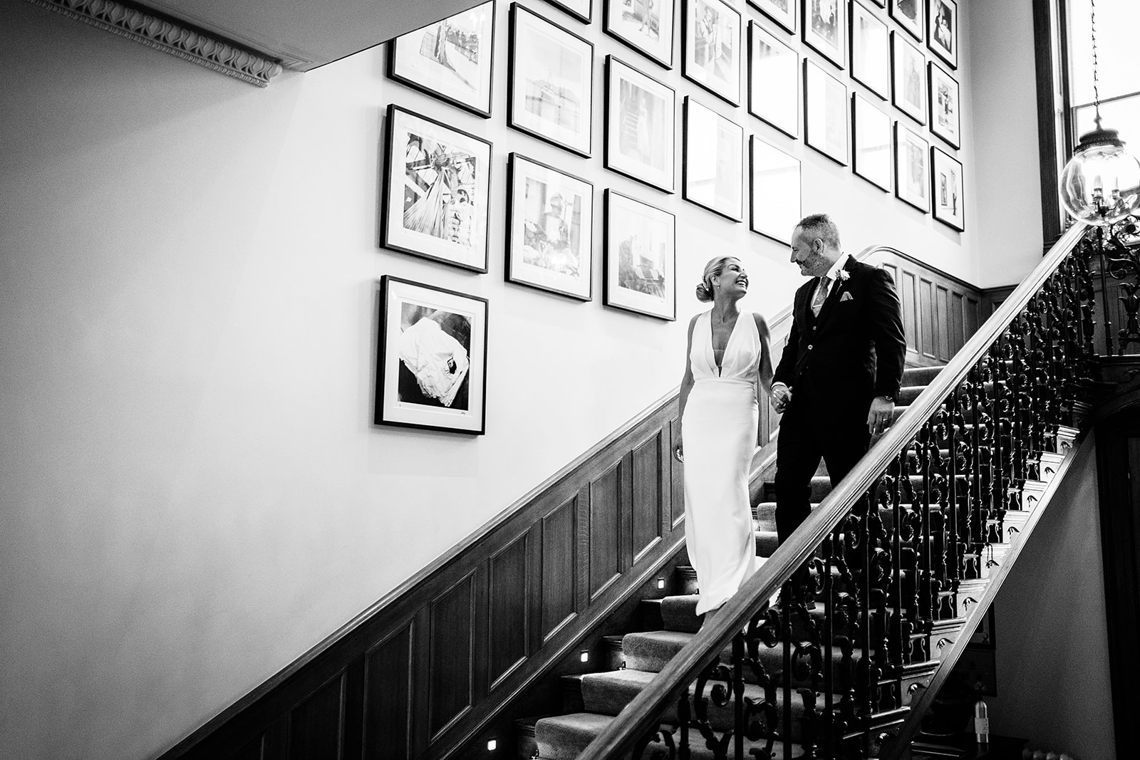 bride and groom coming down stairs heckfield place