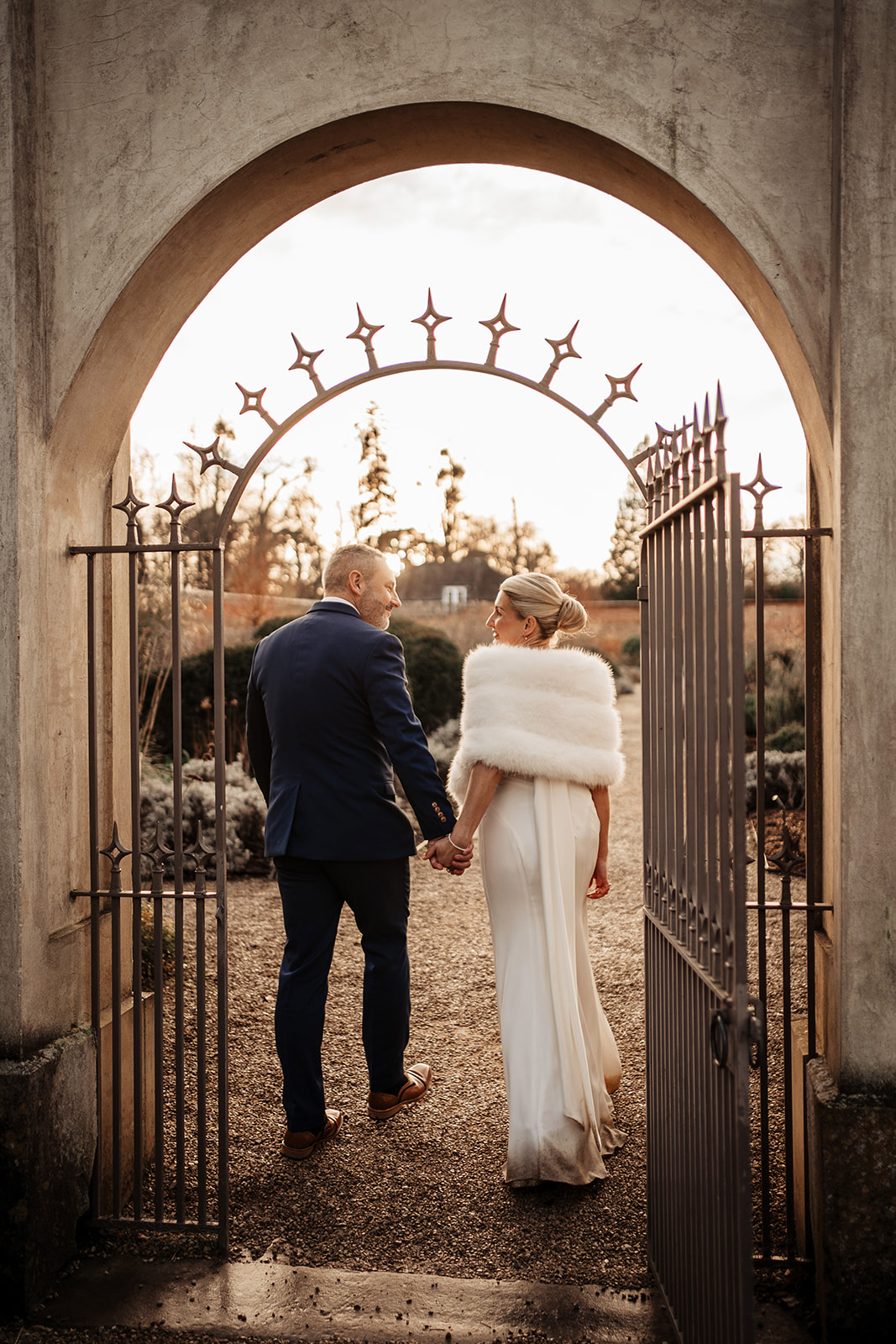 bride and groom walking into walled garden at Heckfield Place