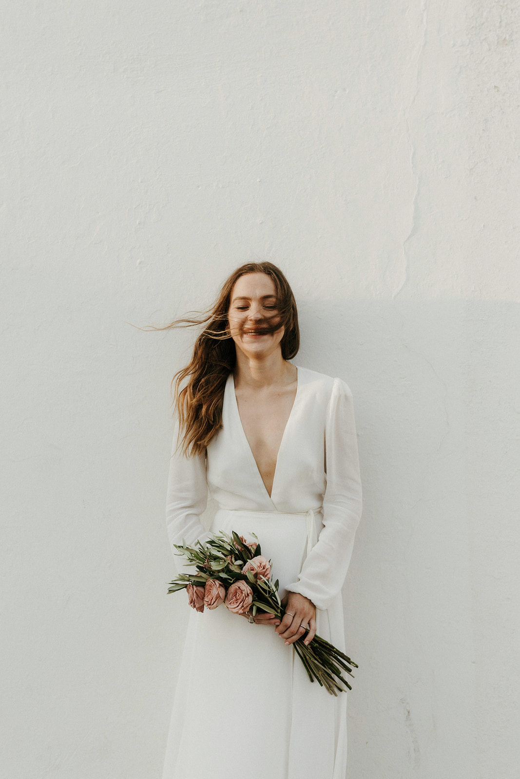 windy portrait of a bride holding her bouquet
