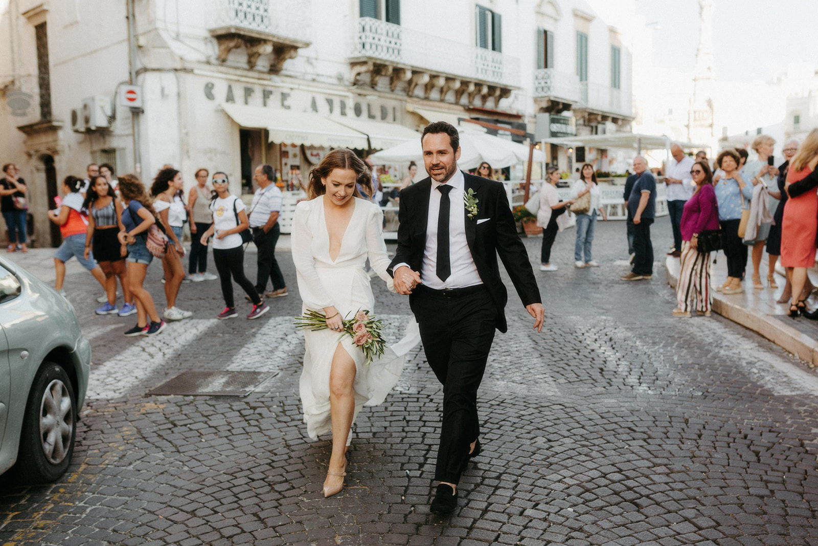 bride and groom walking in the streets of Ostuni, Italy shot on an editorial approach