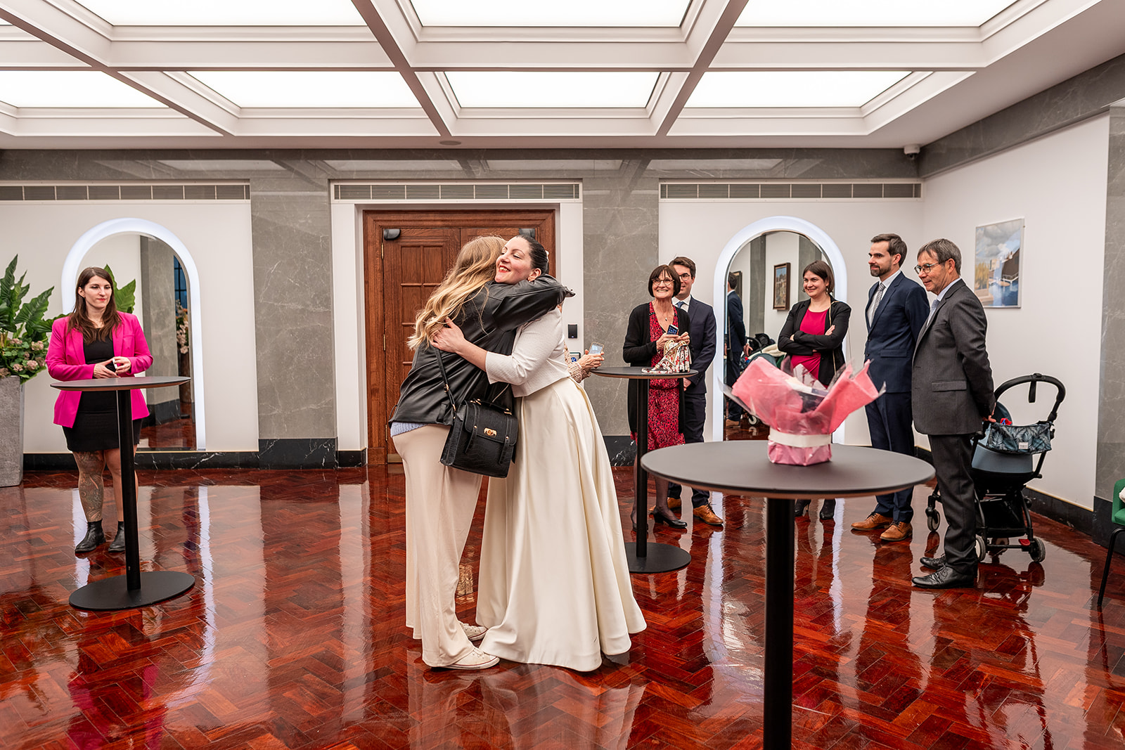 Guests and bride hugging at Camden Town hall waiting area