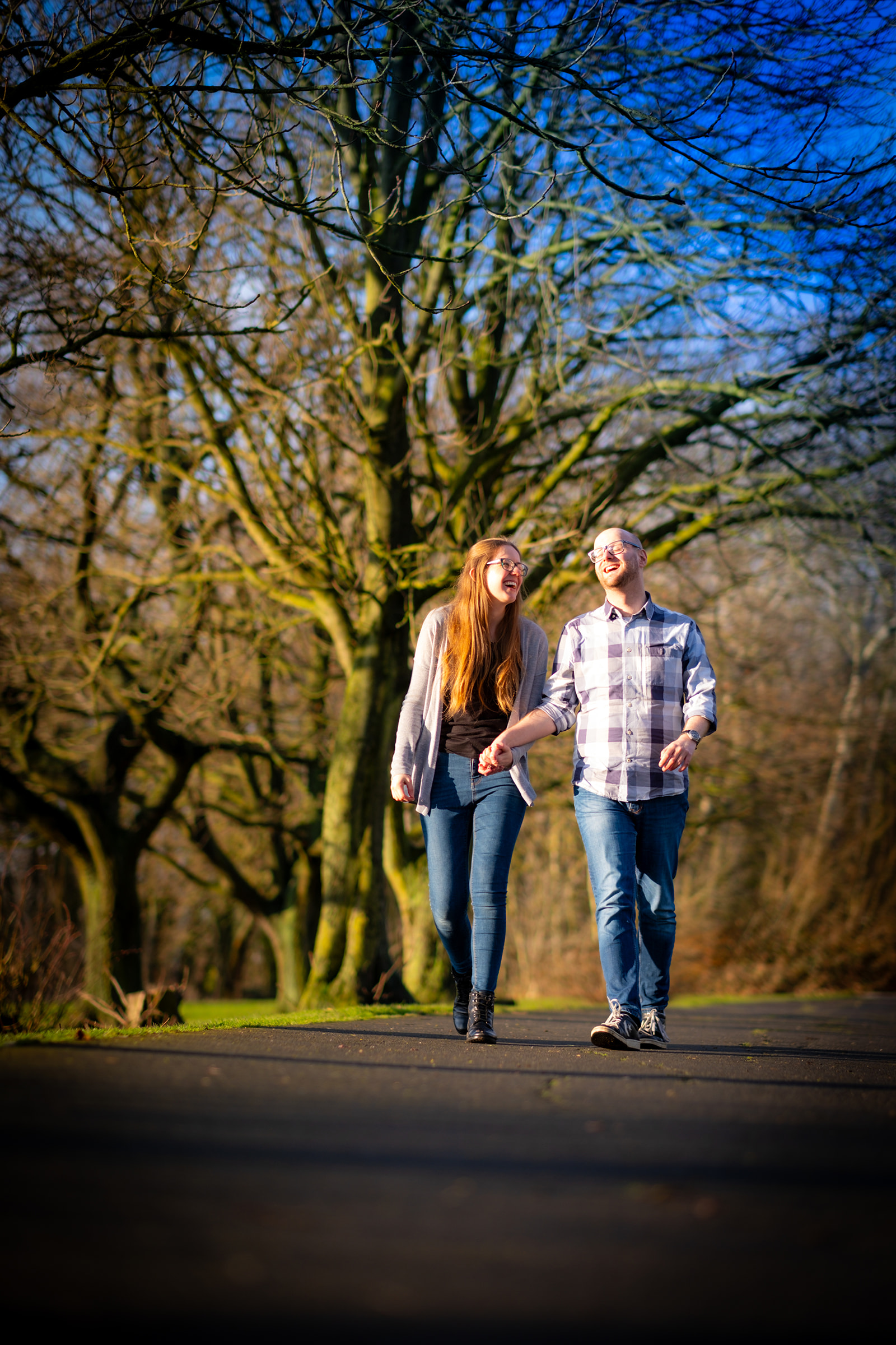 A couple walking down the pathway at Preston Park during their engagement shoot