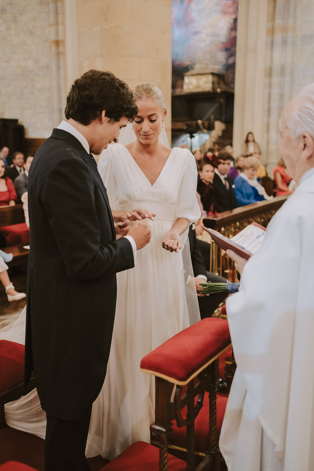 Novio poniendo anillo a la novia en la iglesia